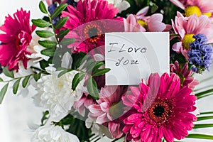 White card for a bouquet with the inscription I love you in a bright beautiful bouquet of flowers