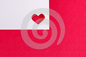 White card with a heart on a red background. Valentine`s Day and cute romantic gifts. Space for text