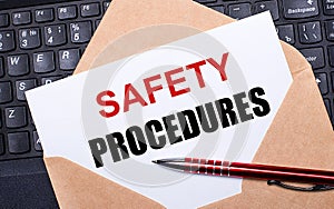 White card with the text SAFETY PROCEDURES in a craft envelope on a work desk with a modern laptop keyboard and burgundy pen. Flat