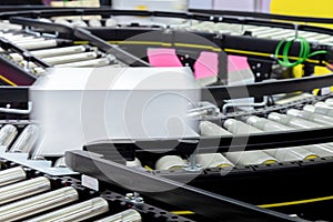 White cardboard box of product packaging moving on conveyor belt of automatic packing machine in manufacturing factory ready for