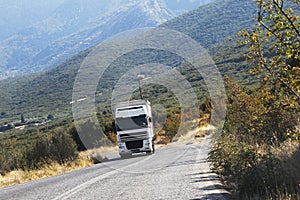 White cargo truck driving on mountain road