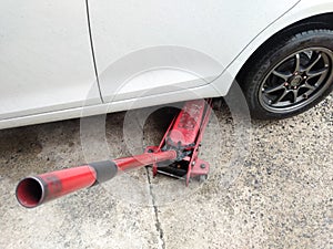 White cars change wheels using a lifting jack