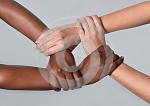 Biely kaukazský žena a čierny americký ruky držanie spoločne proti rasizmus a 