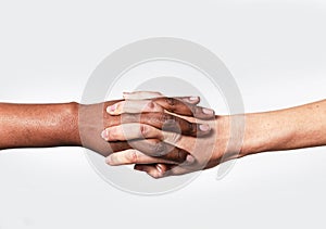 White Caucasian female hand and black African American holding fingers world diversity love