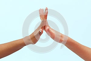 White caucasian female hands and black african american hands stir their fingers together on a blue background. Love and