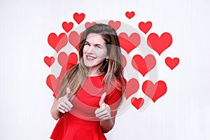 White caucasian woman with red lips giving thumbs up and smiling on heart shaped background.Valentine`s