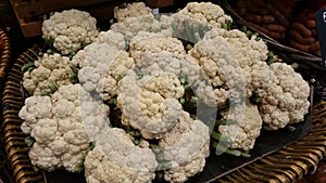 White cauliflowers stack in the basket.