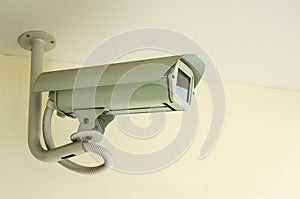 White CCTV security camera on ceiling background ,Closed-circuit television record activity peoples