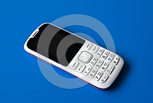 White cell phone with buttons on blue background.