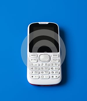 White cell phone with buttons on blue background.