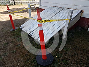 White cellar or basement door with orange cones and caution tape