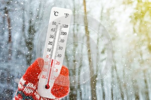 White celsius and fahrenheit scale thermometer in hand. Ambient temperature minus 1 degrees