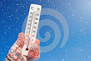 White celsius and fahrenheit scale thermometer in hand. Ambient temperature minus 11 degrees