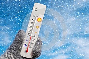 White celsius scale thermometer in hand. Ambient temperature minus 1 degrees