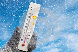 White celsius scale thermometer in hand. Ambient temperature minus 11 degrees