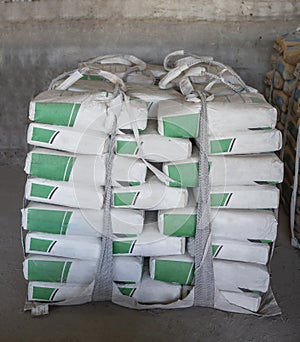 White cement bags stacked in a warehouse. Cement industry  business