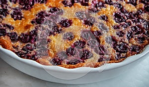 White ceramic baking dish with freshly baked cherry pie CLAFUTI, close-up