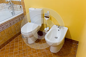 white ceramic bidet and toilet in modern bathroom.