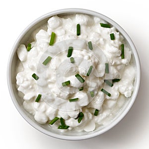 White ceramic bowl of chunky cottage cheese garnished with chive