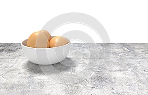 White ceramic bowl ful of eggs. Placed on concrete table.