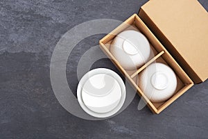 White ceramic bowl in package box on black stone background