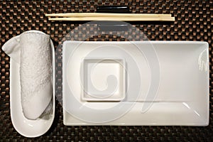 White ceramic bowls and bamboo sticks from sushi with a white towel