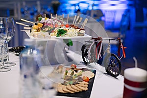 A white ceramic coaster with hors d`oeuvres on the wedding table.