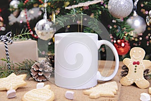 White ceramic coffee cup and christmas decoration on woon table background. mockup for creative advertising text message or