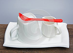 White Ceramic Coffee Set and Red Plastic Spoon