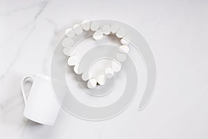 White ceramic cup and heart-shaped marshmallows on white background