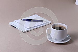 A white ceramic cup for hot beverage on light beige background