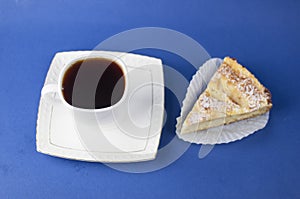 White ceramic cup of hot coffee and sweet pastries on blue background