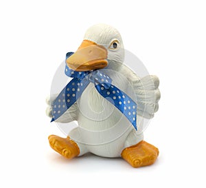 White ceramic duck with a blue bow on a white background