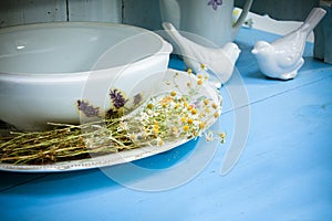 White ceramic kitchenware and chamomiles