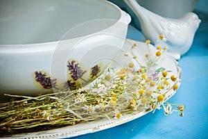White ceramic kitchenware and chamomiles