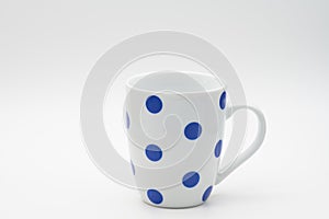White ceramic mug with blue dots isolated on a white background