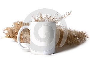 White ceramic mug mockup isolated on white background. Against the background of reeds.