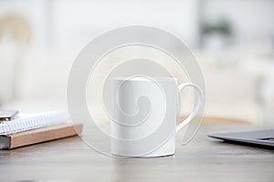 White ceramic mug and notebooks on wooden table indoors. Space for text