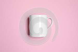 White ceramic mug on pink background, top view