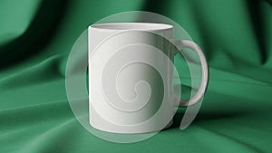 White ceramic mug is positioned on a green fabric surface which is