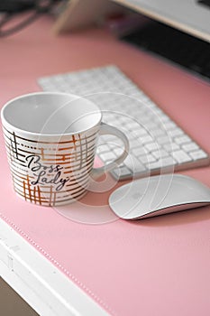 White ceramic mug resting on a desktop computer desk next to a computer mouse