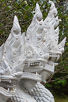 White ceramic naga snake statue on stair of temple