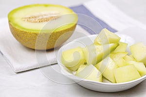 White ceramic plate filled with a variety of freshly sliced fruit, sitting