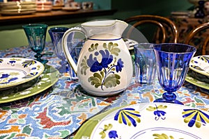 White ceramic plates on a shelf in  store. Designer ceramic plates with a pattern. tableware and eating concept. White jug with