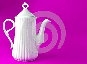 White ceramic teapot on blue background, copy space.