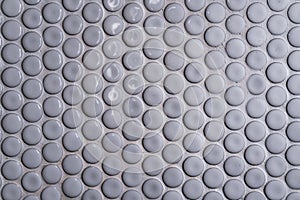White ceramic tile wall with many small round unique pattern. Top view of bathroom wall tile is a round button tile. Circle white