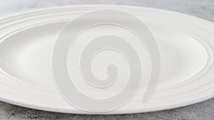 White ceramicplate close-up on a light gray background