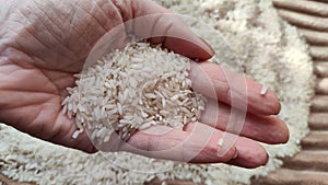 White cereals rice and hand of woman in it. Food for background and texture. Product and food that can be stored for a long time.
