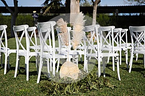 white chairs in the garden for a wedding ceremony. Outdoor event decoration