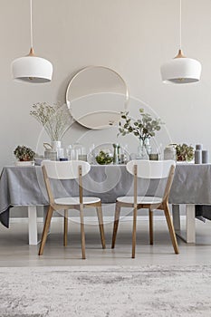 White chairs at table in elegant dining room interior